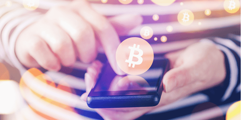 人が両手にスマホを持って仮想通貨のサイトを操作している様子
