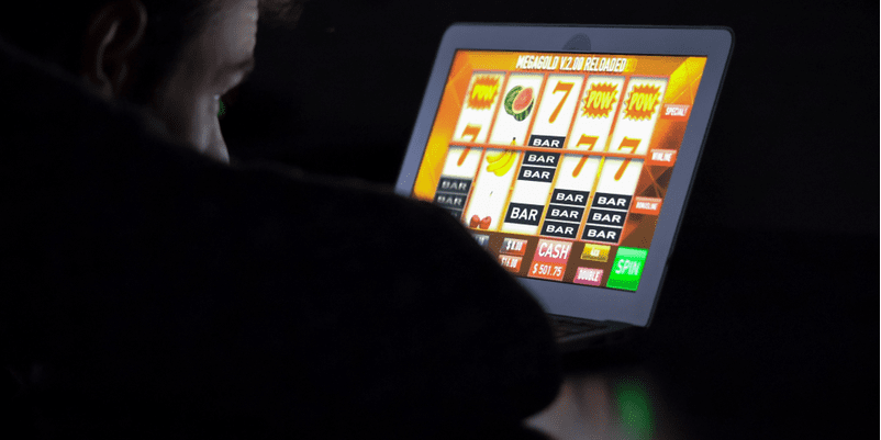 スロットの画像をタブレットで見ている人物の後ろ姿